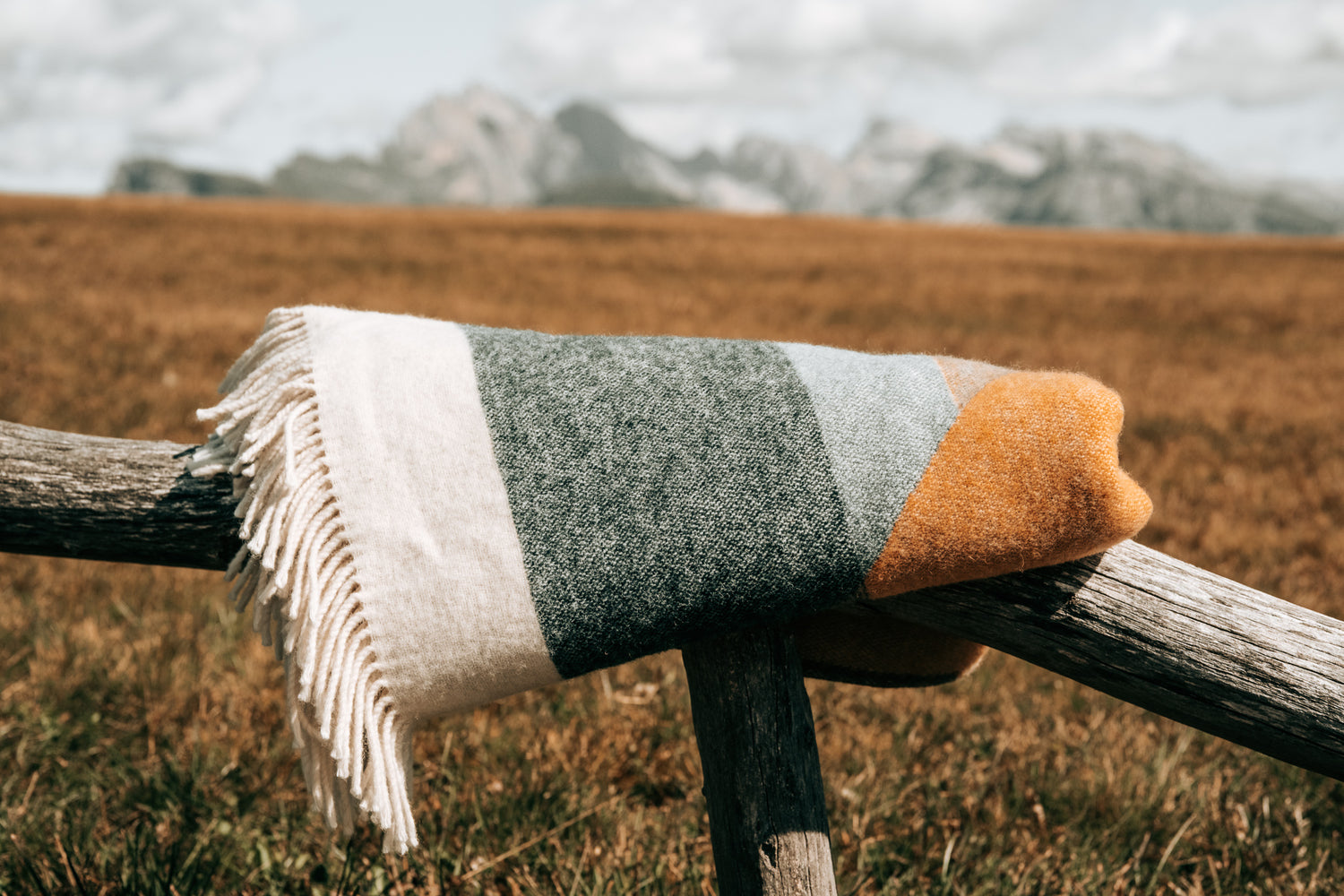 Weiche Kuscheldecke in blau und gelb mit Bergmotiv aus Naturmaterial.