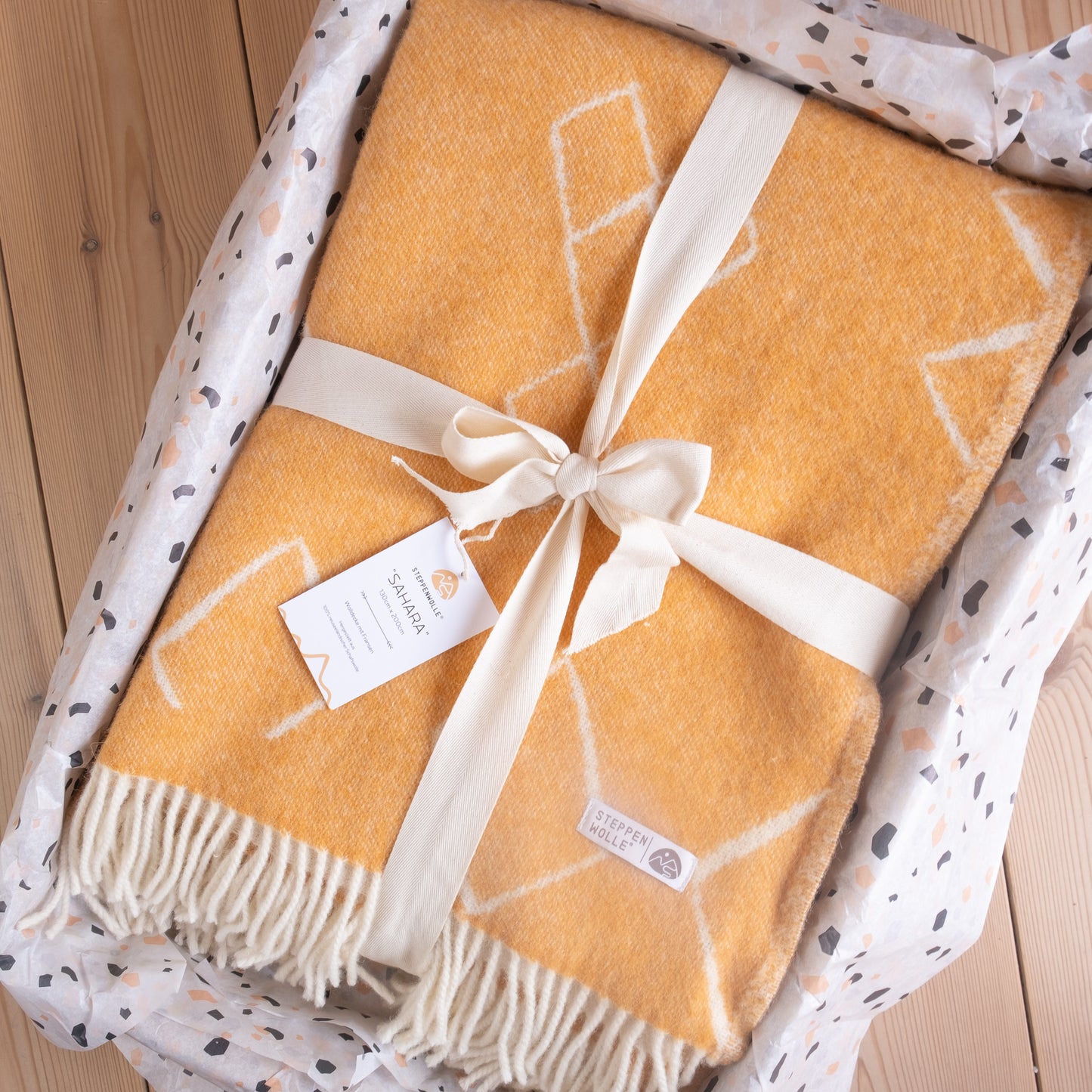 nachhaltige Kuscheldecke in Gelb aus reiner Wolle.