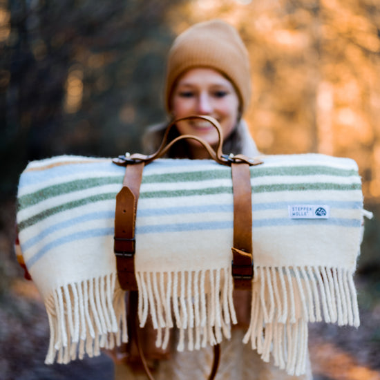 Bunte Kuscheldecke mit Streifen für Picknick und Wandern.